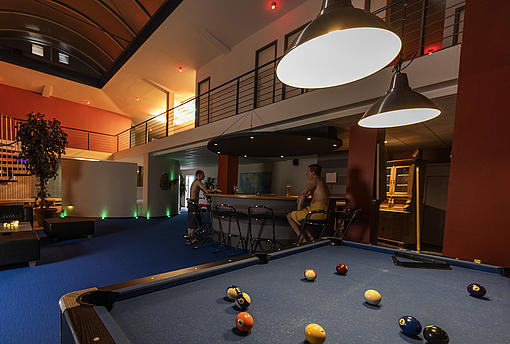 Billiardtisch mit Bar im Hintergrund